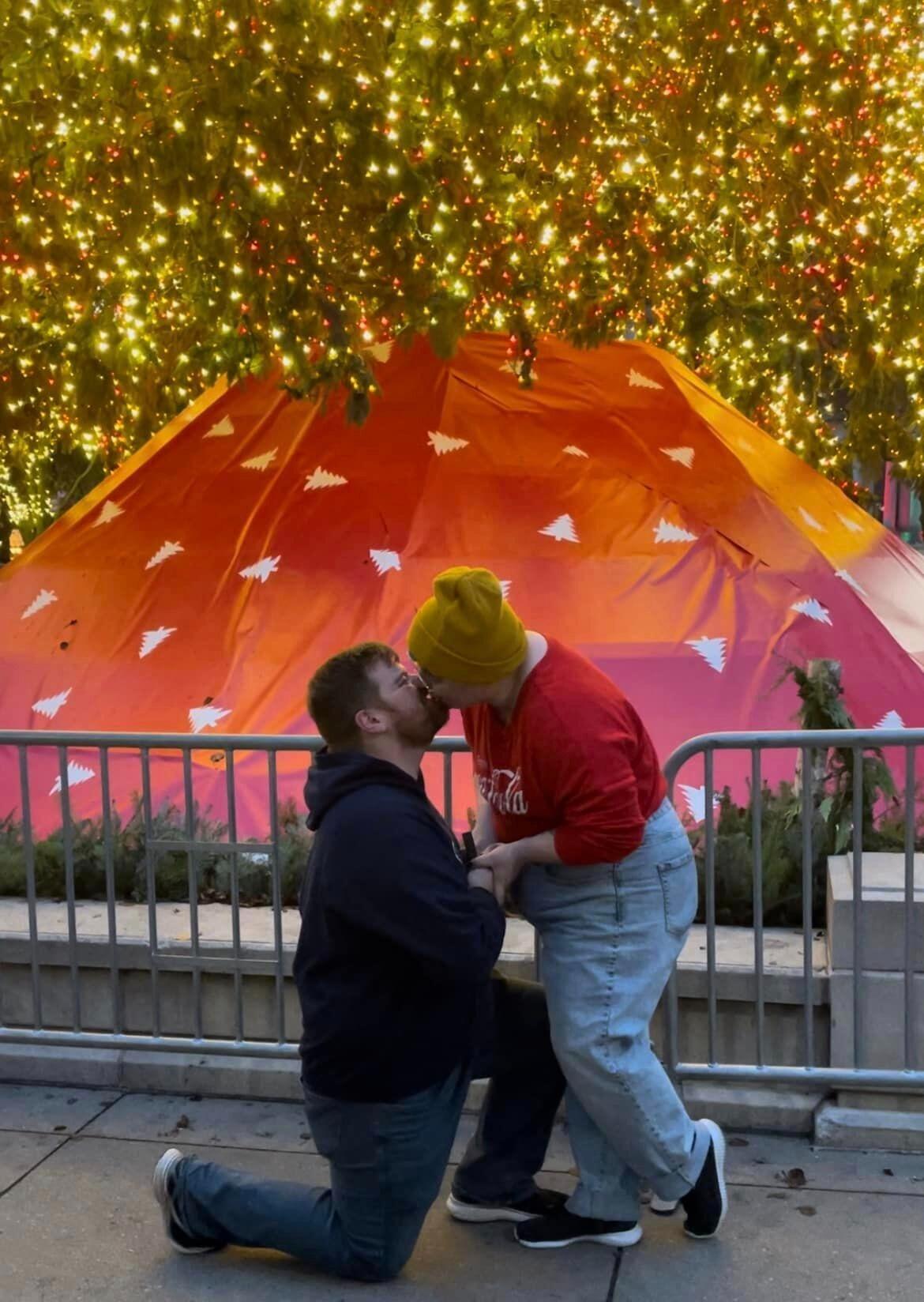 Nick & Rebecca both bring rings to Christkindlmarket 2023. Both of them pull them out in front of the Millenium Park tree, but Nick gets down on one knee first. 