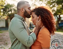 person showing love to their partner with a kiss on the forehead 