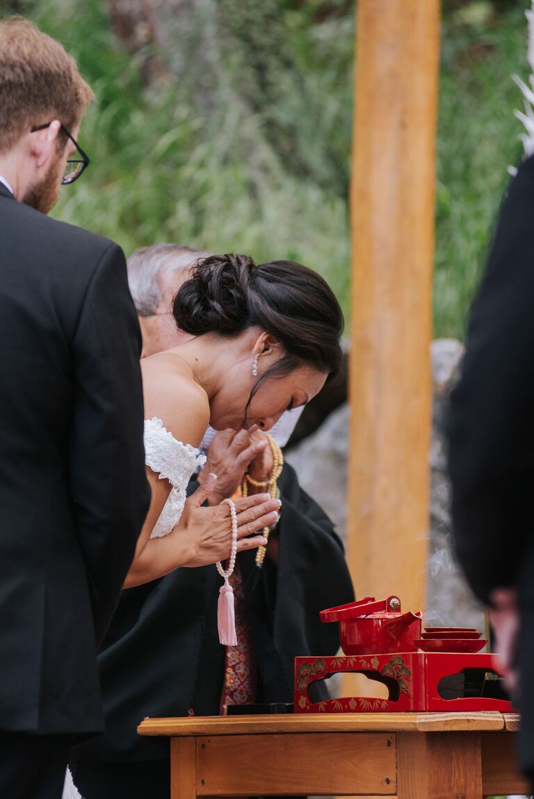Bride bowing during Japanese sake-sharing ceremony