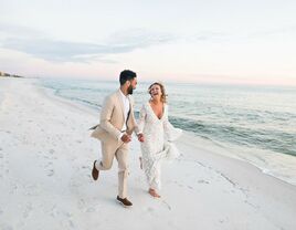 Bride and groom running on a beach