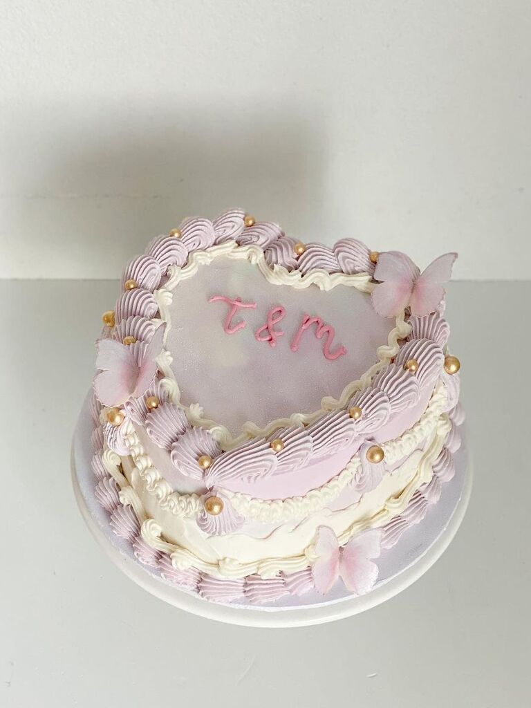 taylor swift themed heart shaped wedding cake decorated with light purple icing and butterflies