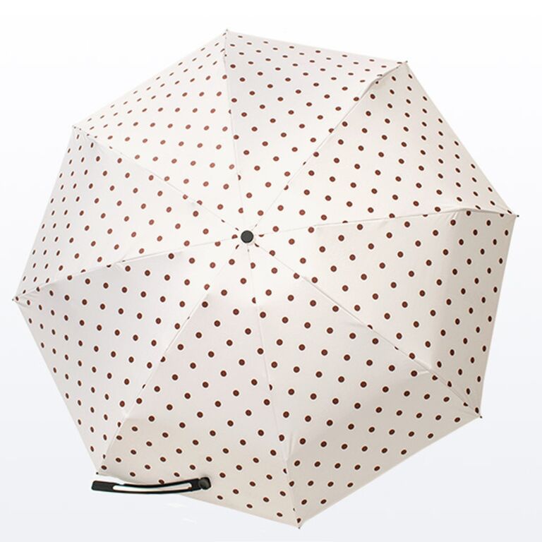 Cream-colored umbrella with chestnut-brown polka dots. 