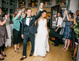 Bride and groom entrance at wedding reception with guests cheering