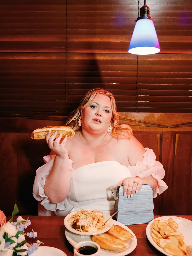 Bride Posing With Diner Food at Restaurant Elopement Party