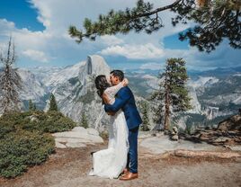 bride and groom embrace on river bank