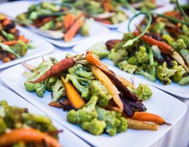 A plate holds a serving of vibrant vegetables. 