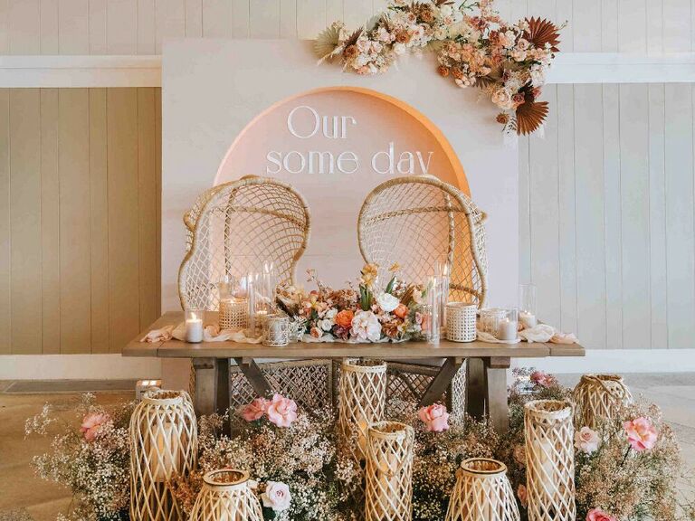 Boho sweetheart table with woven lanterns and wicker chairs