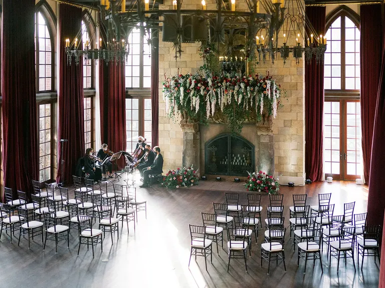 Estate Ceremony Space, Royal Chandeliers, Floral Mantle, Fireplace, Burgundy Draping, String Quartet for Moody Wedding Theme
