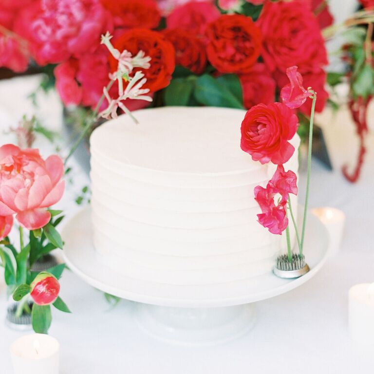 Single-tier white cake with pink fresh flower accents