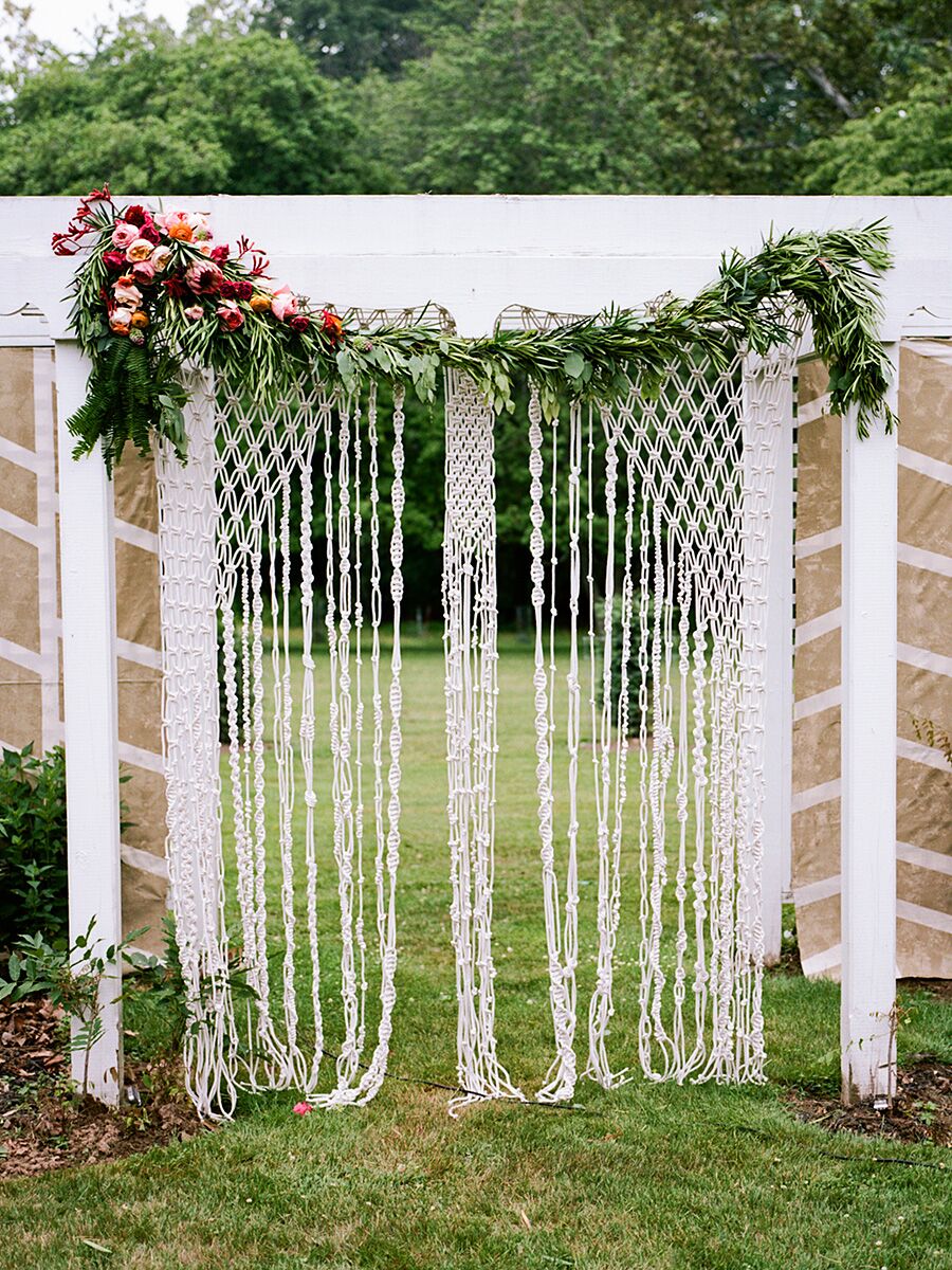 Wedding ceremony macrame backdrop and floral garlands
