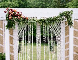 Wedding ceremony macrame backdrop and floral garlands