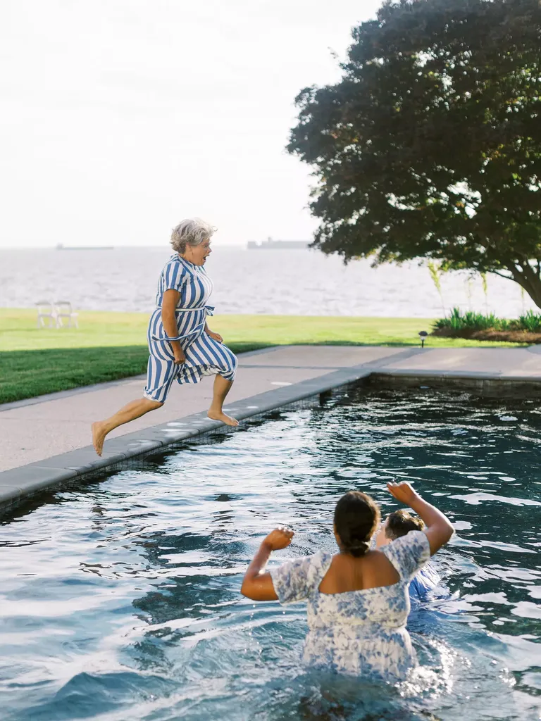 A Guest in Blue-and-White Dress Jumping into a Pool With Couple