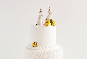 Two bride cake toppers on top of a wedding cake