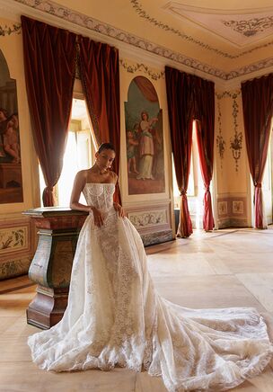 A striking mermaid-style wedding gown with a detachable chapel-length train. Crafted from luxurious lace and adorned with delicate lace appliqués, this gown blends elegance with versatility. The train is fully embellished with lace and effortlessly fastens at the waist, secured with a lace-up back for a seamless fit. The dress features five layers of lining: soft ivory mesh, glittered cappuccino mesh, and additional layers with subtle sequins, ensuring full coverage without transparency while adding a gentle shimmer effect. Callista is also available in classic ivory for custom orders — perfect for brides seeking both timeless beauty and modern detail in their bridal look.