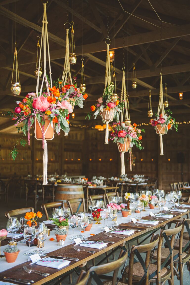 Suspended floral arrangements in barn wedding reception