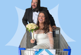 Groom pushing bride holding bouquet in shopping cart at Sam's Club