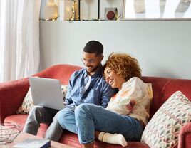 Couple creating bridal shower registry on laptop at home