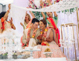 Bride and groom laughing with each other at Indian wedding 