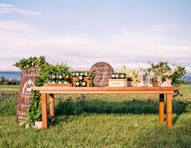 outdoor wedding favor display with wooden table at countryside meadow