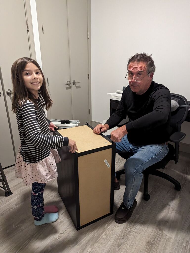 Emma helps Grandpa John put together some furniture for Cassi's office 