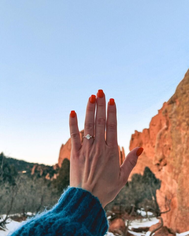 Engagement ring selfie in front of mountains at golden hour