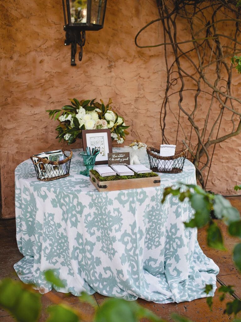wedding welcome table decorated with blue and white patterned tablecloth 