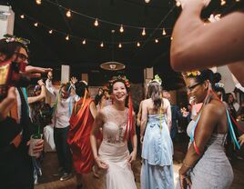 A Ukrainian bride smiles as she dances with her guests.