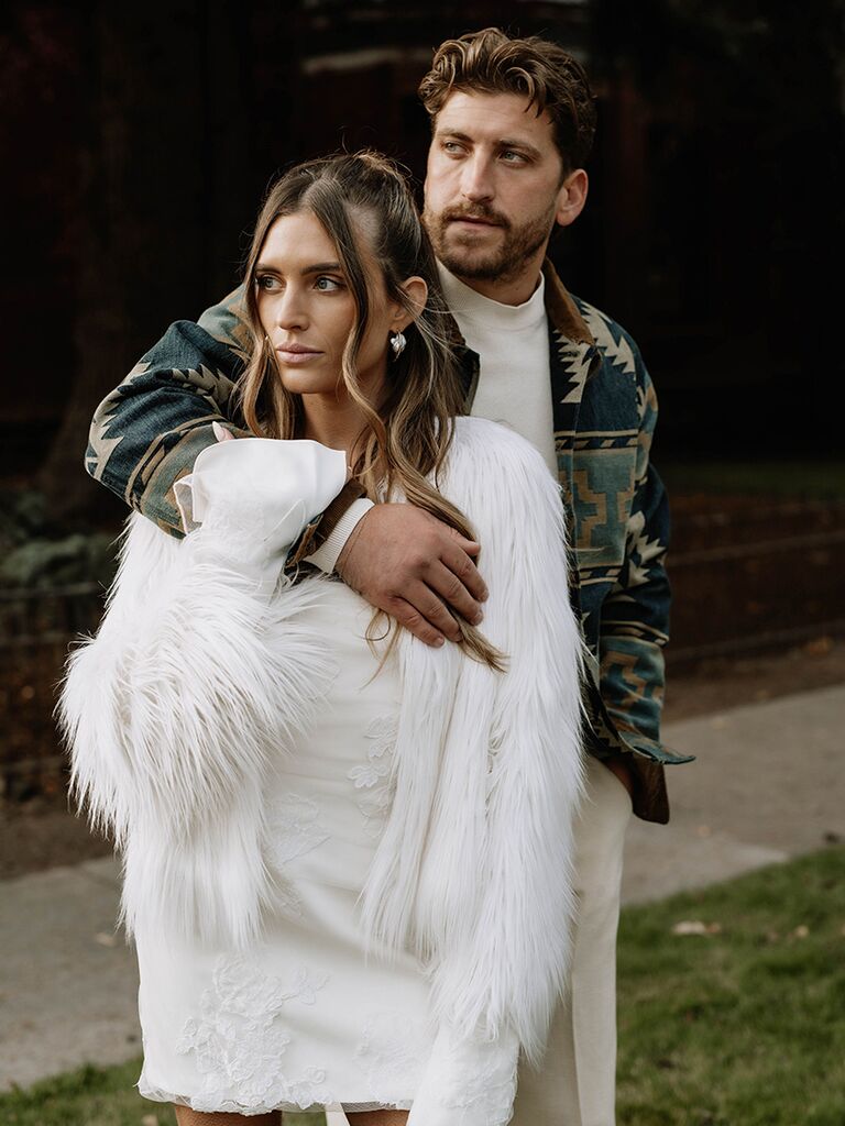Bride in white fur coat and groom in patterned jacket