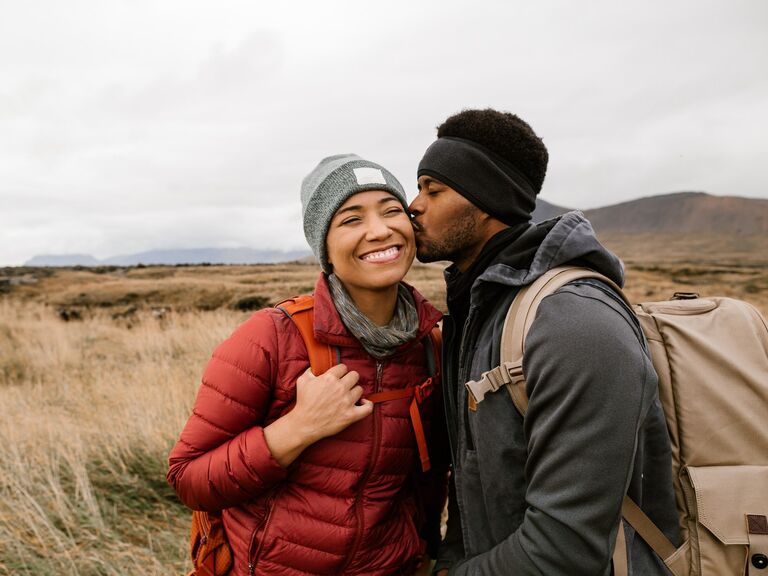 A couple sharing a kiss while on a hike