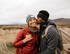 A couple sharing a kiss while on a hike