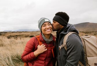 A couple sharing a kiss while on a hike