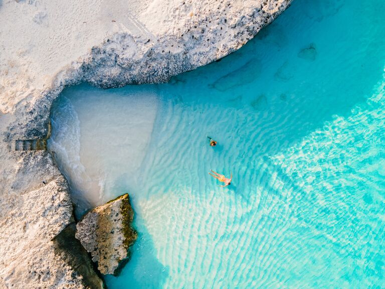 A couple in clear waters on a beach in Aruba