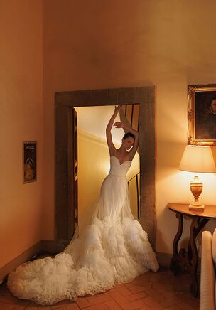 Almost classic: heart-shaped neckline wrapped corset with a skirt consisting of two layers – the bottom skirt of smooth sleek fabric with an overskirt made of lightweight tulle and decorated with voluminous ruches on the edges.