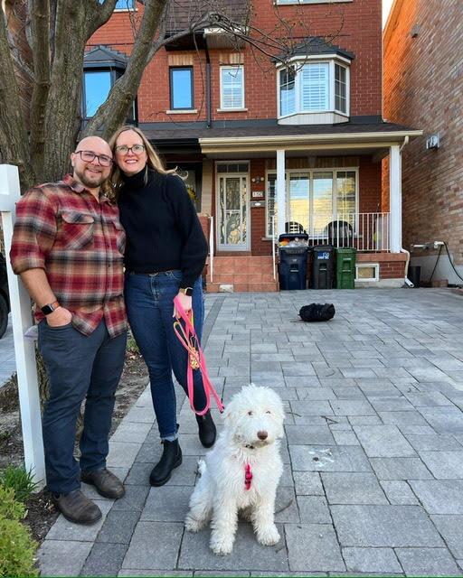 Outside our new home with our Sheepadoodle, Luna.