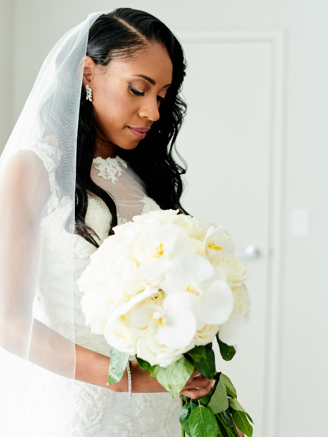 Bride with veil holding white bouquet