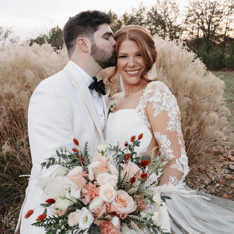Husband kissing his stunning wife on the side of the head