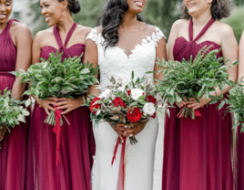 Bride and bridesmaids smiling and holding bouquets together