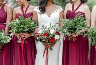 Bride and bridesmaids smiling and holding bouquets together