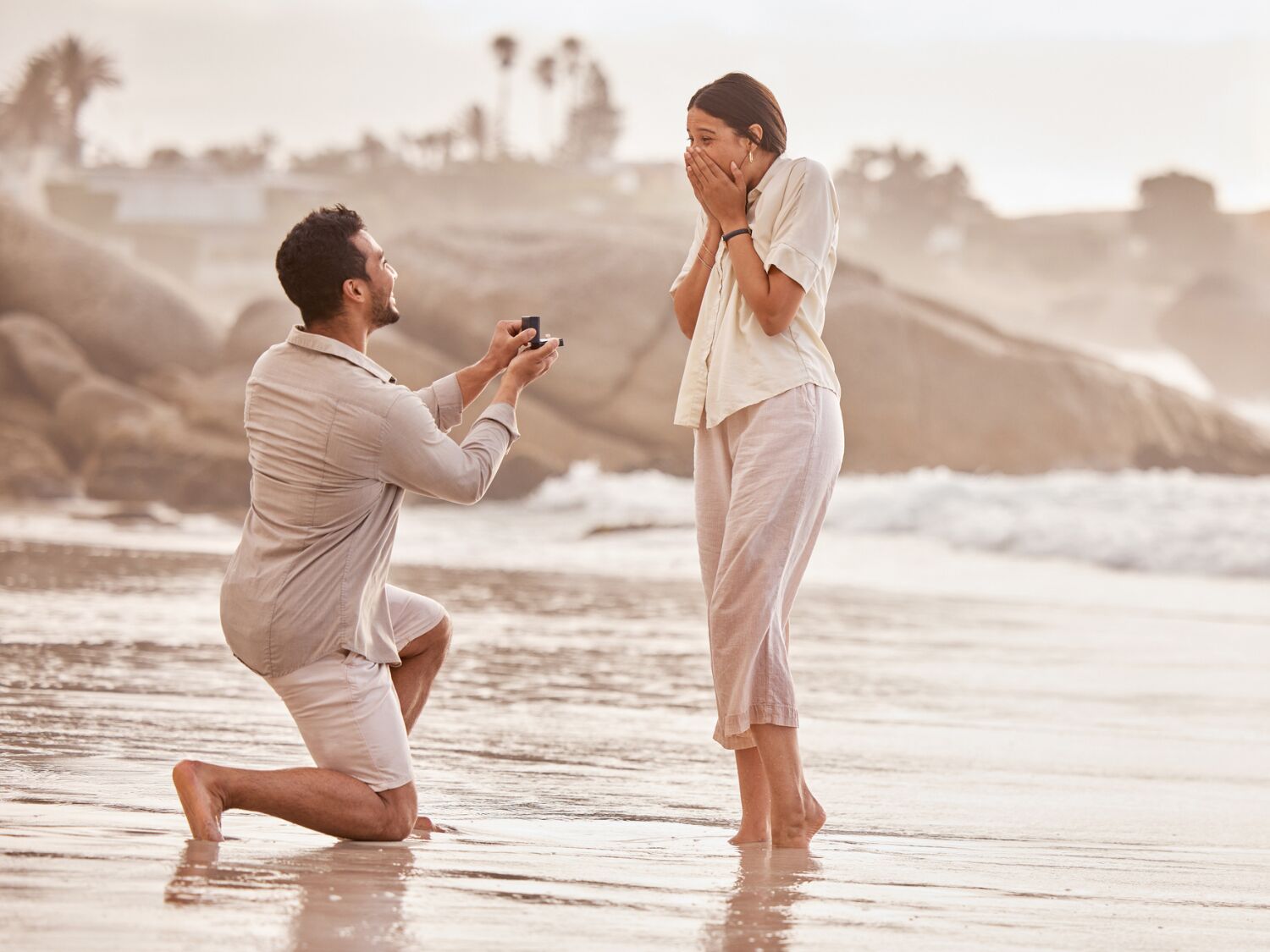 A couple getting engaged on a beach, affordable proposal ideas
