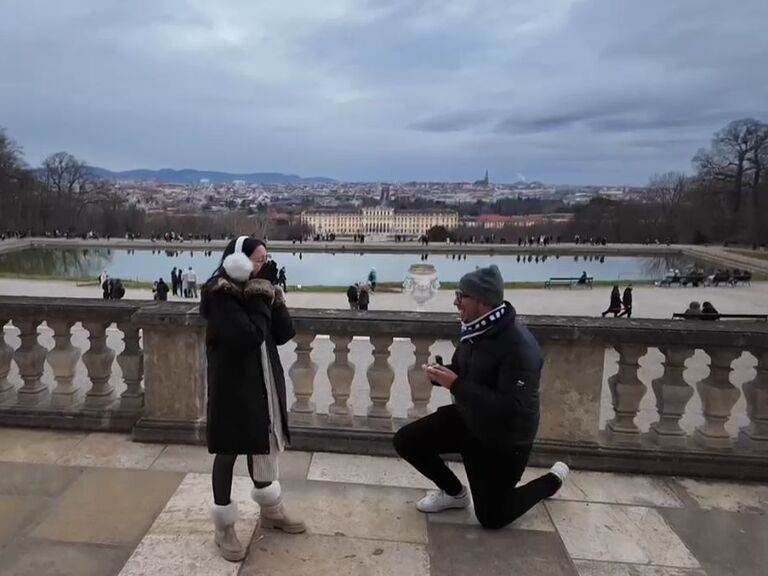 The day arrived — their first morning in Vienna. They met up with two friends who, without Luisa knowing, were helping Erick bring a long-planned moment to life. The four of them had breakfast together at Schönbrunn Palace, sharing laughter, warm drinks, and quiet excitement. Everyone felt the anticipation — everyone except Luisa, who had no idea what was unfolding around her.

After breakfast, they wandered through the palace gardens, taking in the beauty of the place. Eventually, they made their way up toward the Gloriette — a hilltop structure with sweeping views of the city. As Luisa admired the view, their friends helped create just the right distraction. Erick stepped back, took a deep breath, and knelt behind her. In that quiet, perfect moment, he asked the question he had been carrying for years
