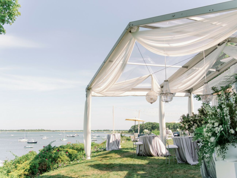 Outdoor reception venue with white tent on the water