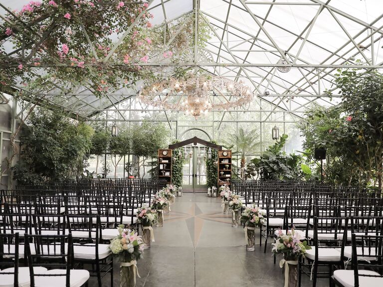 Stunning greenhouse ceremony space with hanging flowers and foliage
