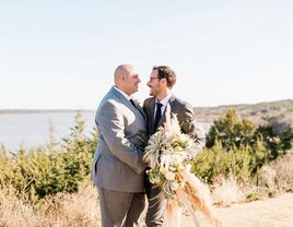 LGBTQ+ couple embracing on rustic lakeside overlook