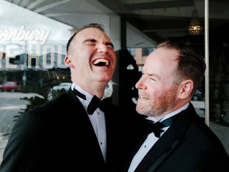 Grooms laughing together after the wedding.