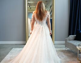 woman in wedding dress facing mirror