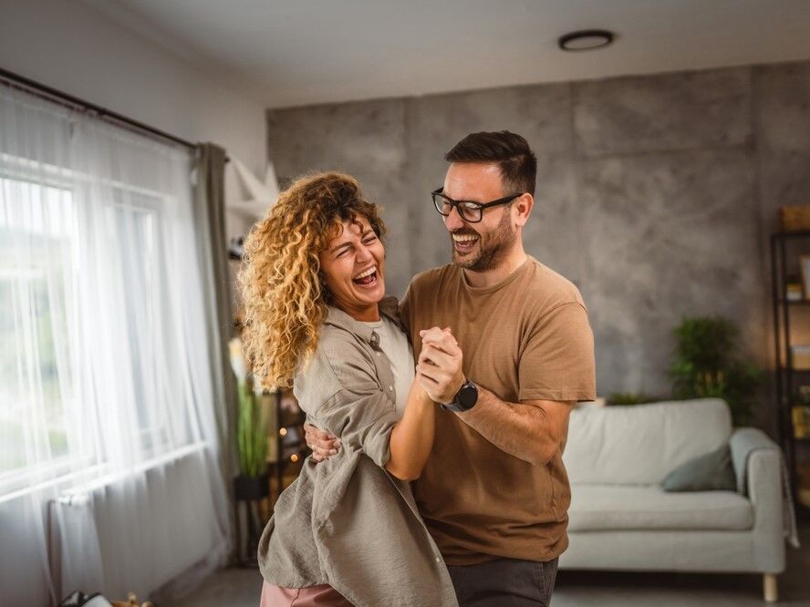 Couple dancing together in a living room