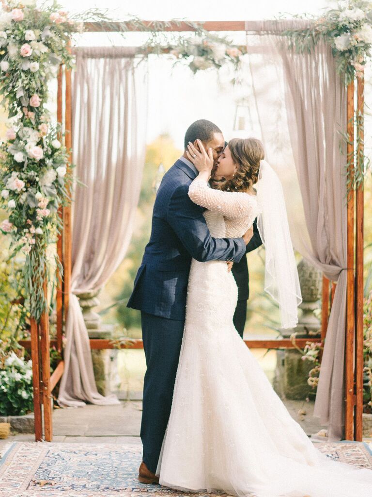Bride and groom kissing at altar