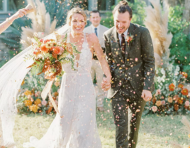 Bride and groom walking down the aisle through champagne sprays at The Greenhouse at Driftwood wedding venue in Dallas 