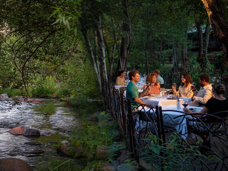 Group having dinner on patio by river