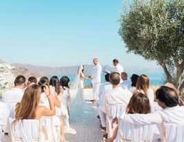 Guests wearing white during wedding ceremony